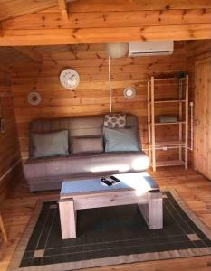 a room with a couch and a table in a cabin at Quinta chalet in Alcantarilha