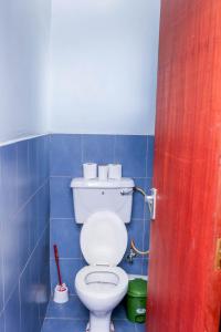 a bathroom with a toilet in a blue tiled room at Tiamcy homes in Kisumu