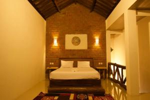 a small bedroom with a bed in a brick wall at Mu Homestay in Tetebatu