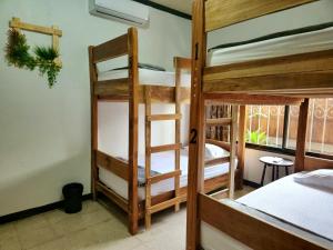 a room with three bunk beds and a window at Hostel El Pretal in Liberia