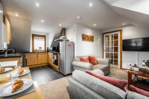 a living room with a couch and a kitchen at Aldo's Place in Dingwall