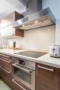 una cucina con piano cottura in acciaio inossidabile forno superiore di Precioso piso moderno: Terraza, A/C, NetFlix, WiFi a Valencia