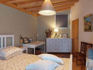 een slaapkamer met 2 bedden, een bureau en een televisie bij Casa do Brejão 1 bedroom cottage in Odemira