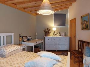 a bedroom with two beds and a desk and a tv at Casa do Brejão campo e praia in Odemira