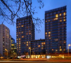 華沙的住宿－Vorto Apartament 3 - Warszawa Centrum，一座高大的建筑,晚上有灯