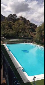 a large blue swimming pool with a mountain in the background at apartamento arroyo in Benaocaz