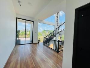 uma sala de estar vazia com uma escada e portas de vidro em Black Mustang Hotel em Dambulla
