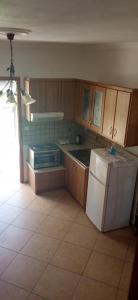 a kitchen with wooden cabinets and a white refrigerator at Soustas Apartments in Longos