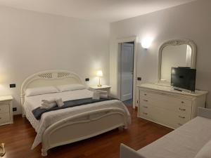 a white bedroom with a bed and a mirror at Foresteria La Corte in Castrezzato