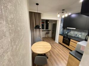 基希讷乌Sweethome Riscani的一间带木桌的小厨房和一间餐厅