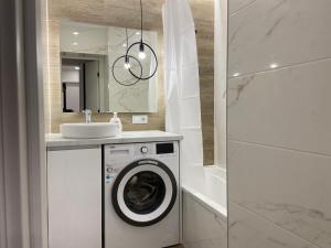 ein Badezimmer mit einer Waschmaschine und einem Waschbecken in der Unterkunft Sweethome Riscani in Chişinău