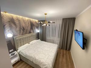 Schlafzimmer mit einem Bett und einem Flachbild-TV in der Unterkunft Sweethome Riscani in Chişinău
