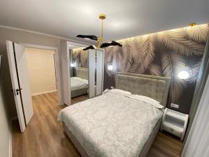 基希讷乌Sweethome Riscani的一间卧室配有一张床和壁画墙