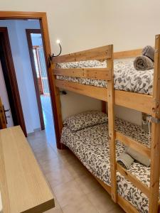 マリーナ・ディ・ラグーザにあるBeachFront Rooms Marina di Ragusaの二段ベッド2台とテーブルが備わる客室です。