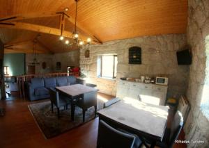 a kitchen and living room with a table and chairs at Rilhadas Casas de Campo in Fafe