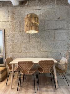 a table and chairs in a room with a brick wall at A Das Marias VINTAGE in Ourense