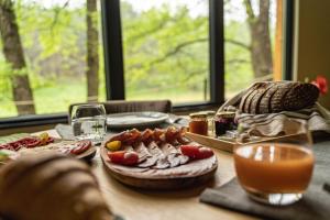 una mesa de madera con comida y bebidas. en Bakony Deep Forest Vendégház, en Bakonyszentlászló