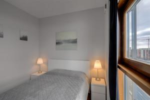 a bedroom with a bed and two lamps and a window at Vorto Apartament 3 - Warszawa Centrum in Warsaw +41 photos