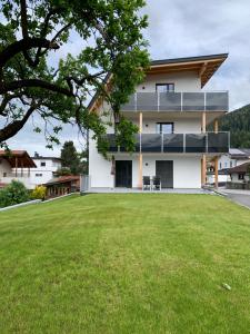 ein Haus mit großem Rasen davor in der Unterkunft Apartments Oliver, Axams in Innsbruck