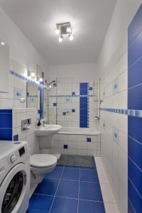 a blue and white bathroom with a washing machine at Vorto Apartament 3 - Warszawa Centrum in Warsaw