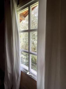 una ventana con una cortina blanca en una habitación en Forest Villa, Kaatsheuvel, en Loon op Zand