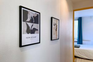 dos cuadros enmarcados en una pared en un dormitorio en Appart 2 personnes Cherbourg Hyper centre, en Cherbourg-en-Cotentin