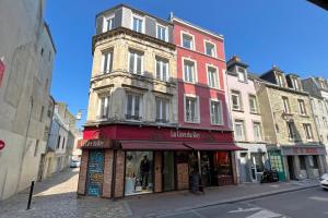 un edificio alto en una calle de la ciudad con una tienda en Appart 2 personnes Cherbourg Hyper centre, en Cherbourg-en-Cotentin