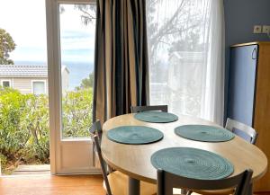 mesa de comedor con 4 sillas y ventana grande en Le Fango, en Lumio