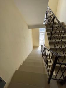 una escalera en una casa con barandilla de metal en Апартаменты у Натальи, en Aktau