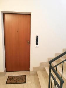 una puerta marrón en un edificio con escaleras en Appartamento BluOltreMare, en San Vito lo Capo