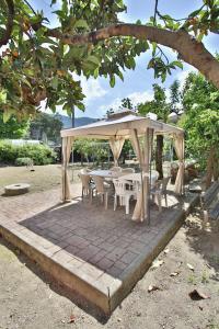 um pavilhão com mesas e cadeiras sob um dossel em Appartamento sole&mare em Levanto