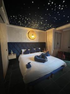 um quarto com uma cama grande e almofadas azuis em Riad Dar Chadia em Marrakech