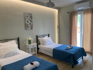 a bedroom with two beds and a window at Adriana's Summer House in Kassiopi