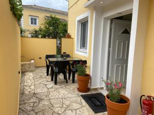 un patio con tavolo e sedie in un edificio di Adriana's Summer House a Kassiopi