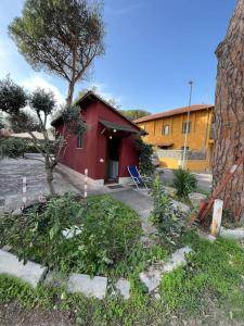 une maison rouge avec un arbre devant elle dans l'établissement Cottage degli acquedotti, à Rome