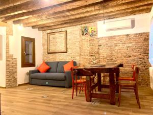 uma sala de estar com um sofá e uma mesa em Old town Chioggia apartments em Chioggia