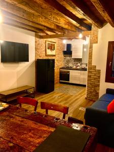 een woonkamer met een zwarte koelkast en een keuken bij Old town Chioggia apartments in Chioggia