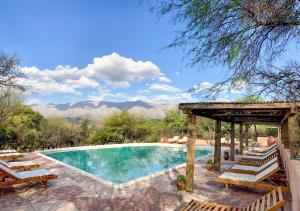 a swimming pool with chairs and a pergola at Posada Rural La Matilde in San Javier