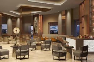 a lobby of a hotel with chairs and a bar at AC Hotel by Marriott Guadalajara Expo in Guadalajara