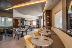 um restaurante com mesas e cadeiras e uma cafetaria em AC Hotel by Marriott Guadalajara Expo em Guadalajara