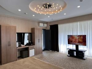 ein Wohnzimmer mit einem Flachbild-TV in einem Zimmer in der Unterkunft Astor Hotel in Samarkand