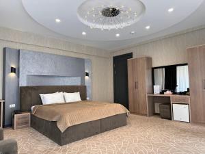Un dormitorio con una cama grande y una lámpara de araña. en Astor Hotel, en Samarkand
