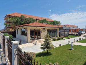 a house with a garden and a fence at Valurile Mării Vama - Veche in Vama Veche