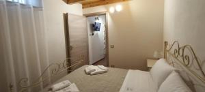 a bedroom with a bed and a mirror and a door at Casetta Castelvecchio in Palazzolo Acreide