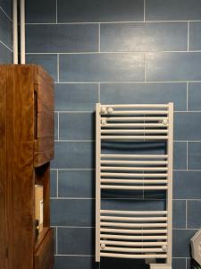 eine blau geflieste Wand mit einem Handtuchhalter im Bad in der Unterkunft Chambre privée dans appartement in Bobigny