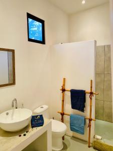 a bathroom with a sink and a toilet at Antema Lodge Secteur Tamarindo, piscine, yoga, gym, jungle et paix in Tamarindo