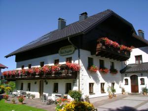 un gran edificio blanco con flores en el balcón en Haus Brigitte, en Fuschl am See