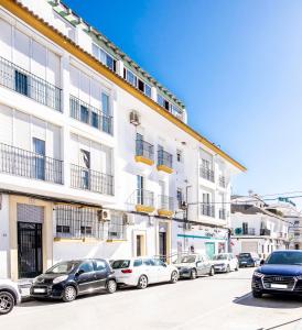 a row of cars parked in front of a white building at La Ensenada, apartamento junto al mar in Barbate
