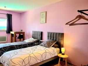 sypialnia z 2 łóżkami i różową ścianą w obiekcie Chambres d'hôte ROUQUART w mieście Méjannes-le-Clap