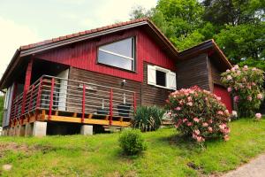 czerwono-czarny dom z dużym balkonem w obiekcie Chalet idéal 4-8 pers avec garage 20 mn Gérardmer w mieście Vienville